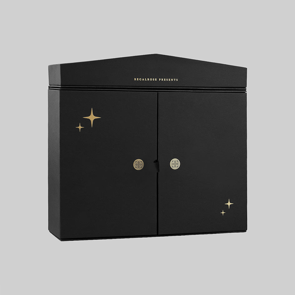Black Regalrose advent calendar box at an angle, with gold foil stars and Regalrose Presents lettering above the doors