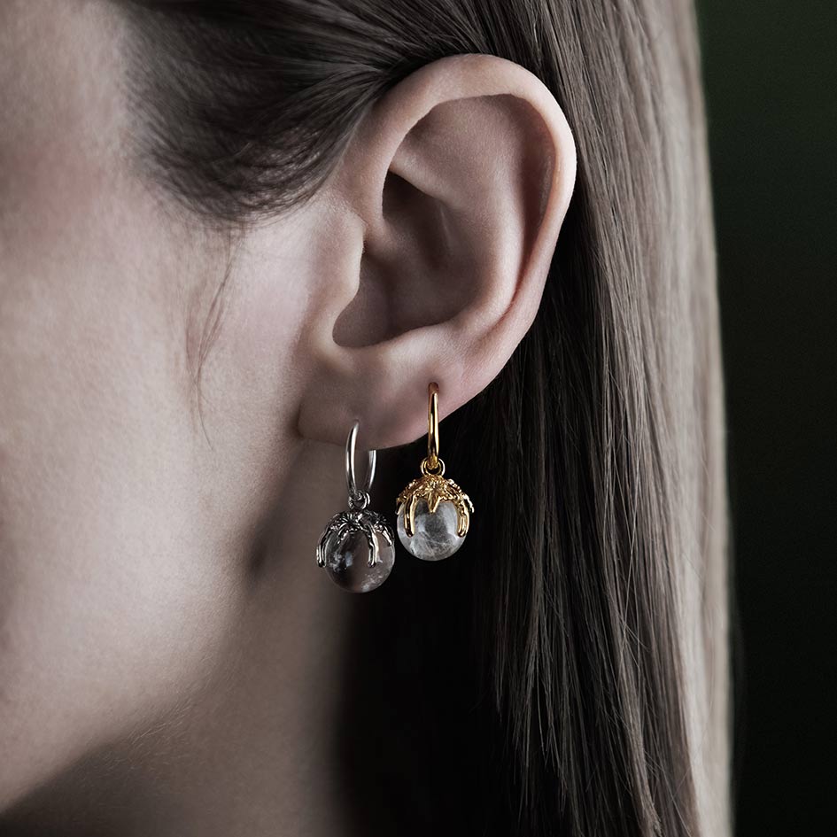 Model wearing crystal ball hoop earrings