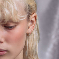model wearing the gold titanium ring as ear piercings