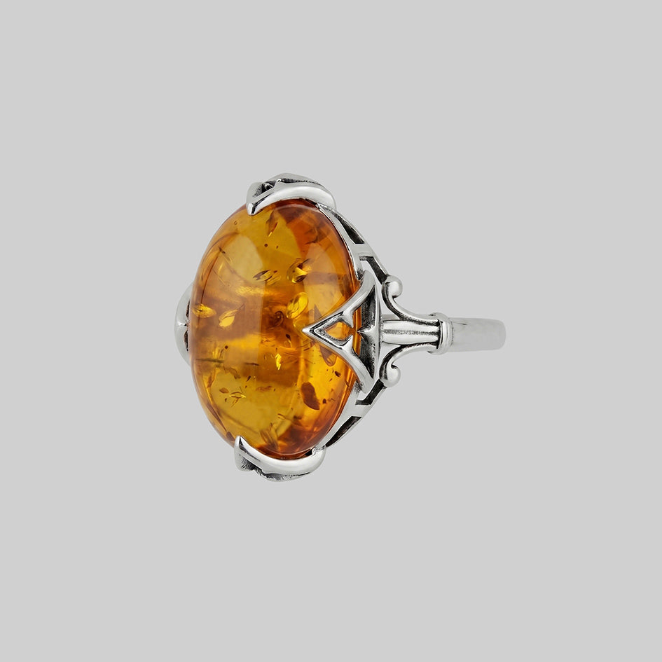 Amber Cabochon ring, features inclusions and an intricate gothic style setting.