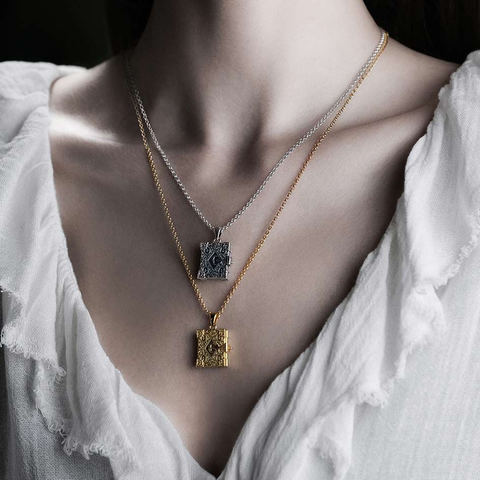 Model wearing layered book of spells locket necklaces