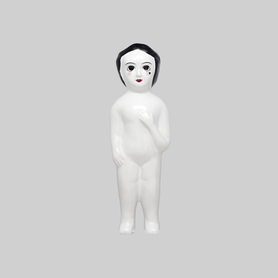 White ceramic figure with black hair small heart shaped tattoo on face