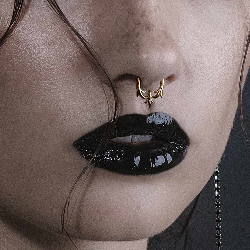 Model wearing Hault gold heraldic lily septum clicker ring