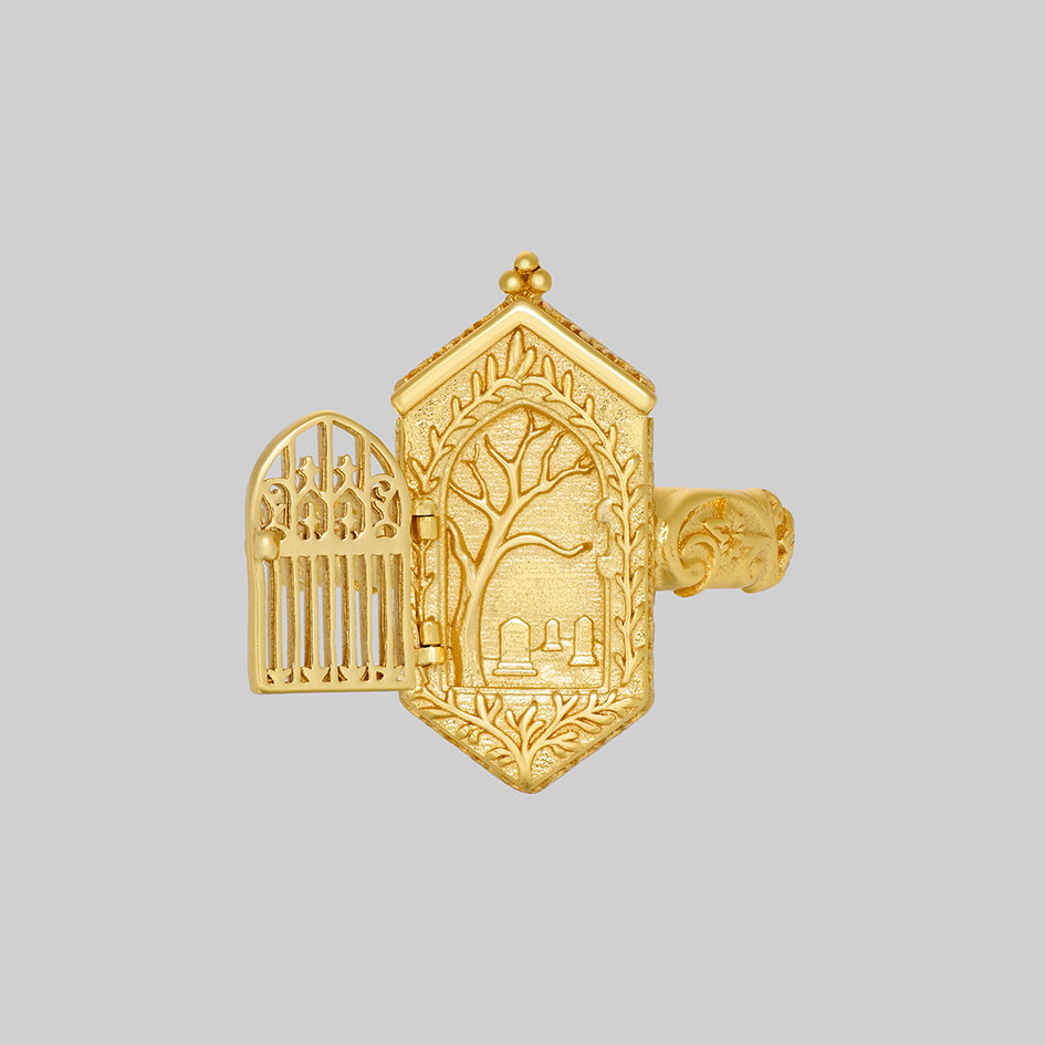 Gold iron gate ring open, revealing engraved tree and gravestones