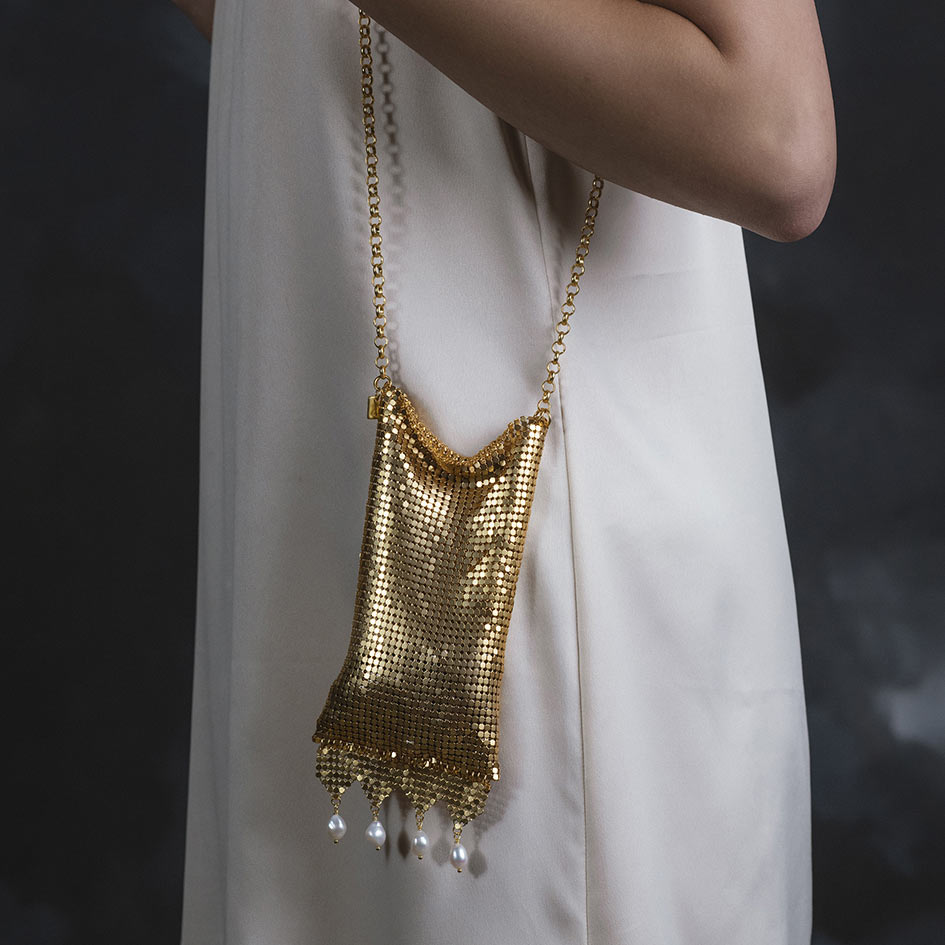 Model wearing Oda gold armoured pearl drop bag