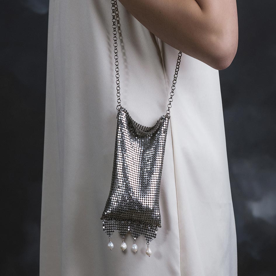 Model wearing Oda silver armoured pearl drop bag