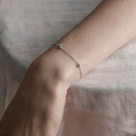 Silver dainty barbed wire bracelet worn on a models wrist