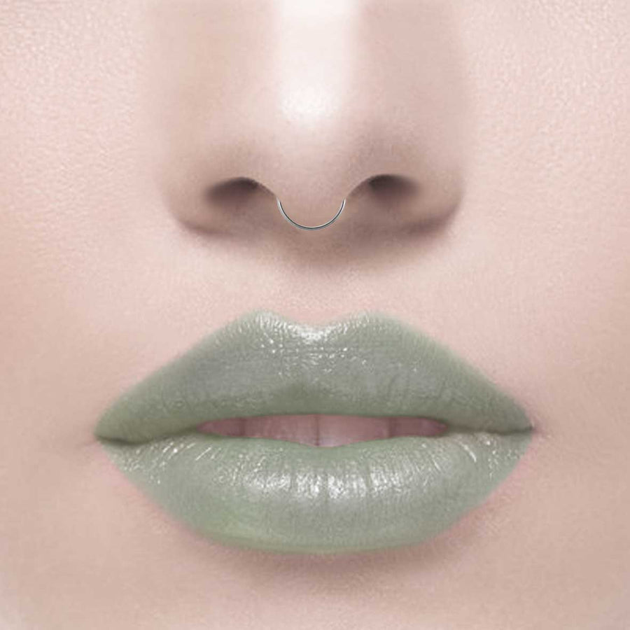 A dainty silver septum clicker ring worn by a model