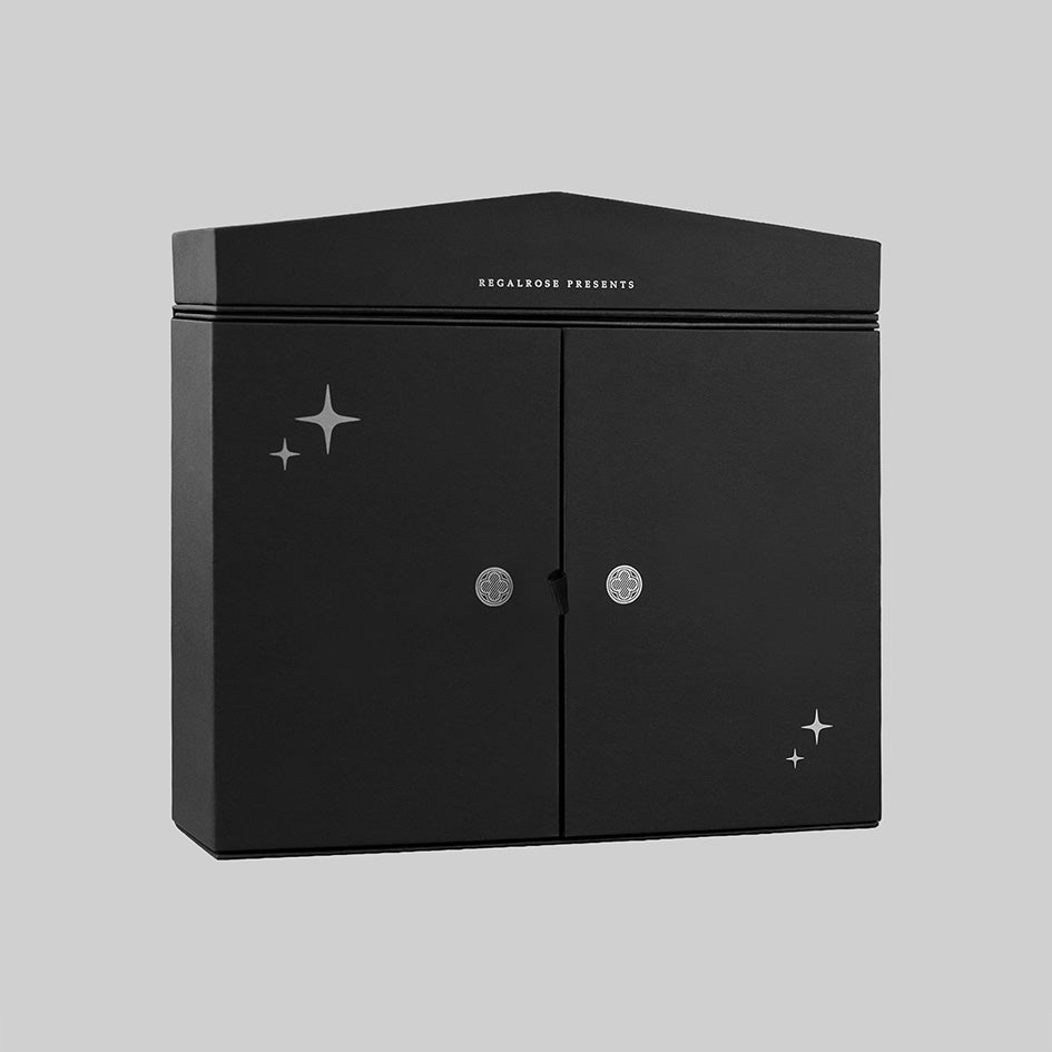 Black Regalrose advent calendar box at an angle, with silver foil stars and Regalrose Presents lettering above the doors