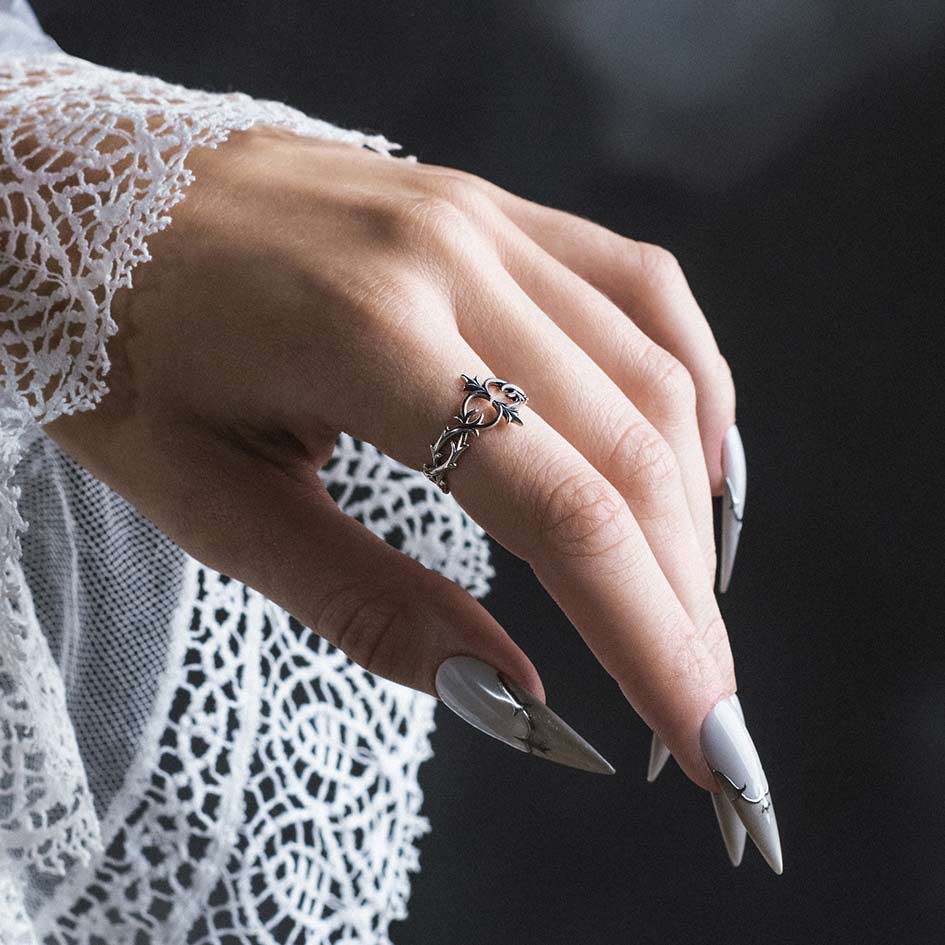 Model wearing Alianor sterling silver heraldic lily ring on index finger