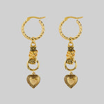 gold hand holding heart earrings