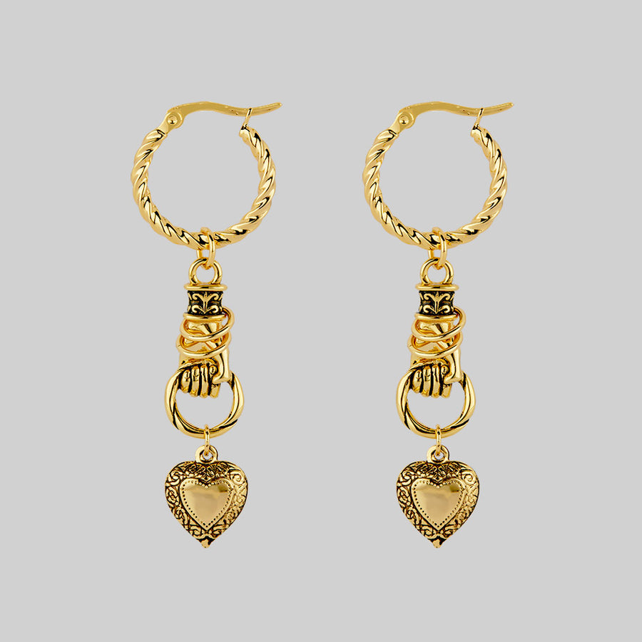 gold hand holding heart earrings