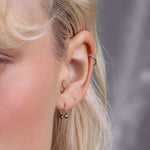 model showcasing the gold titanium barbell ring in her earlobe piercing