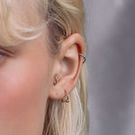 model showcasing the gold titanium barbell ring in her second earlobe piercing