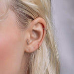 model showcasing the gold titanium barbell ring as an ear piercing
