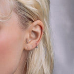 model wearing the silver barbell ring as an ear piercing