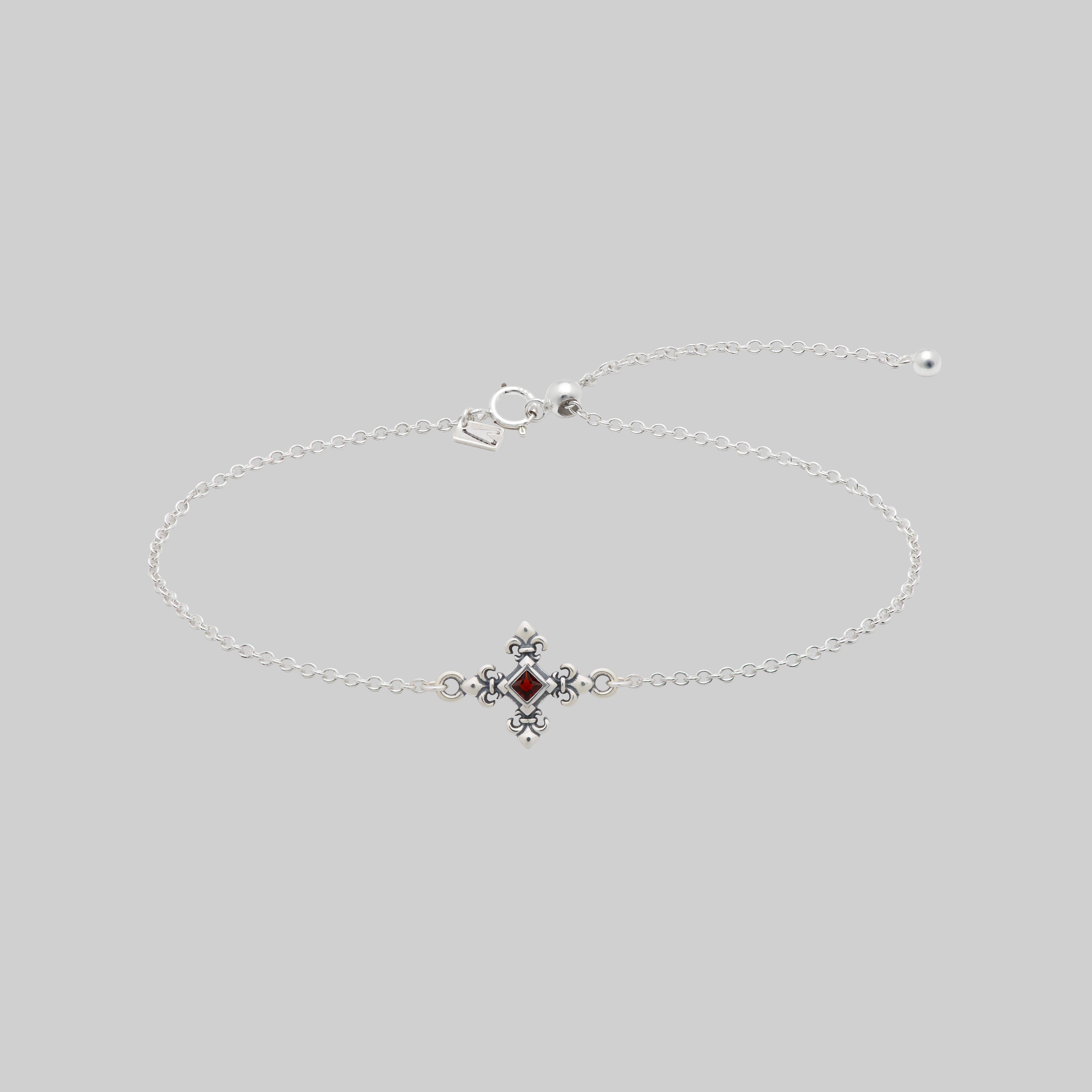 Silver dainty bracelet with a garnet stone and decorative clasp