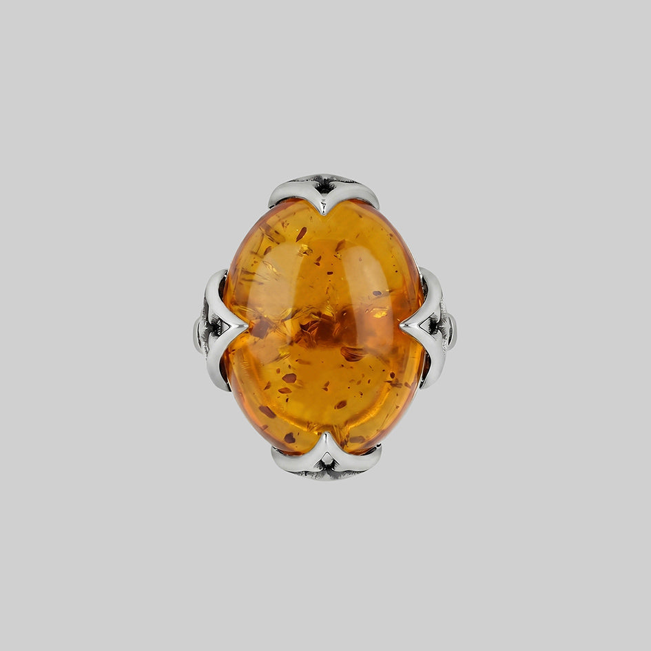 Amber Cabochon ring, features inclusions and an intricate gothic style setting. 