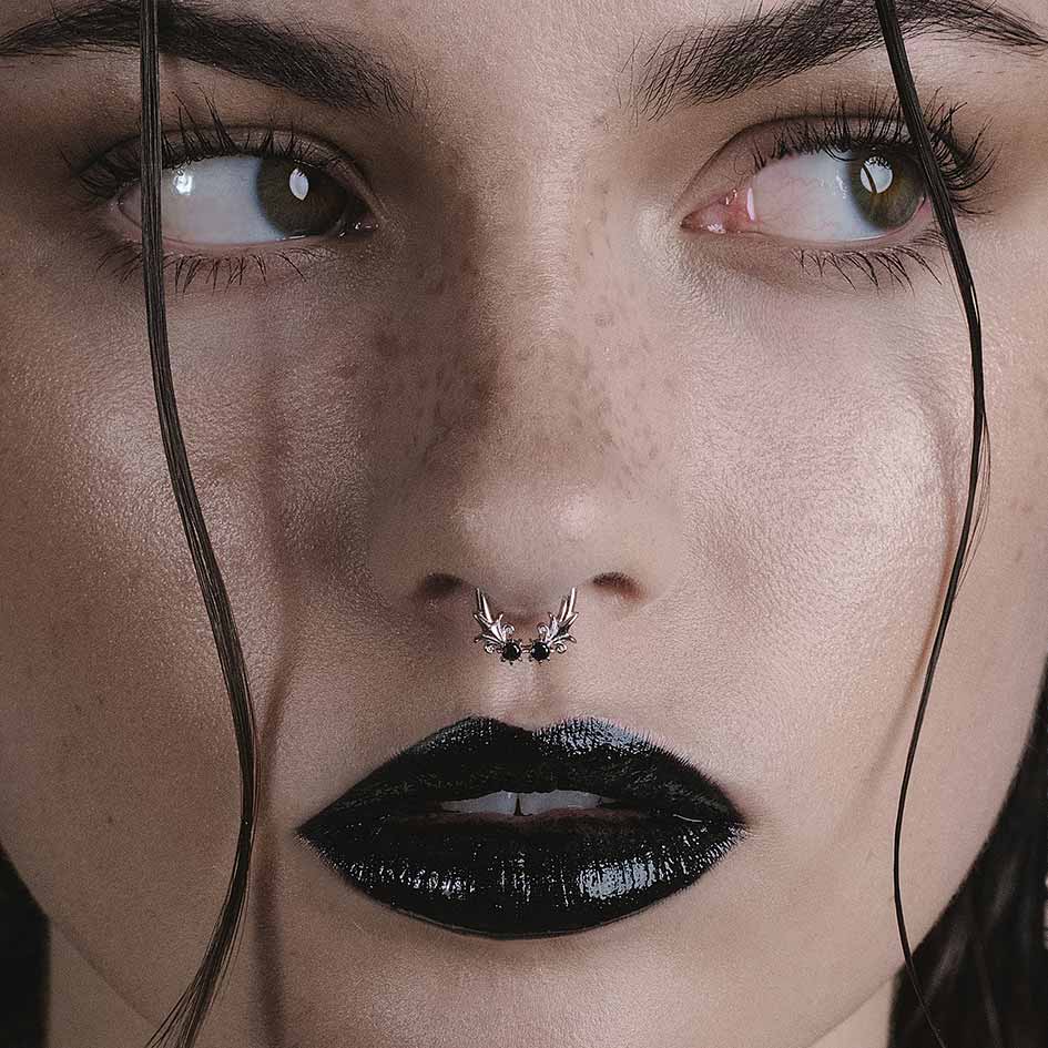Model wearing Fiora silver heraldic lily black onyx septum clicker ring