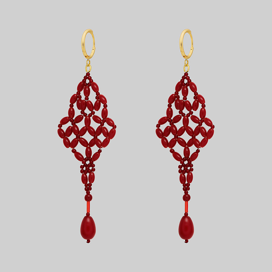 Red beaded chandelier drop earrings with gold hoops, side view