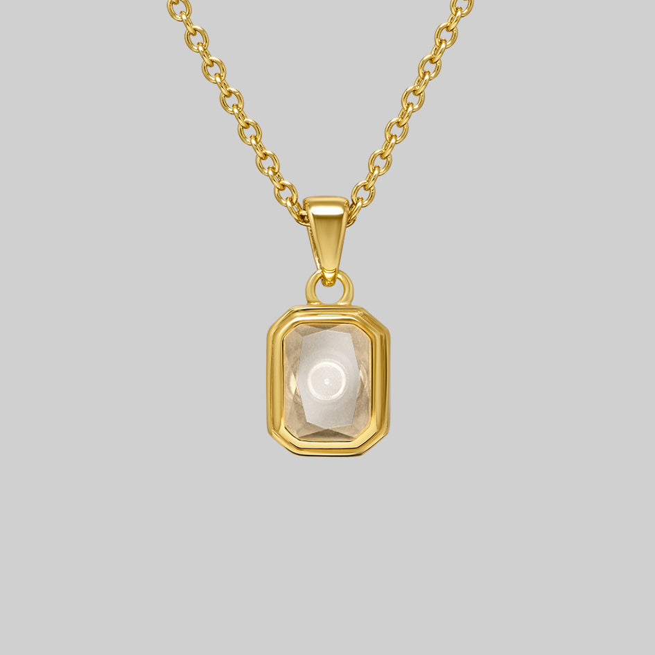 Gold cremation necklace with an emerald cut Clear Quartz pendant, the ashes chamber visible through the stone