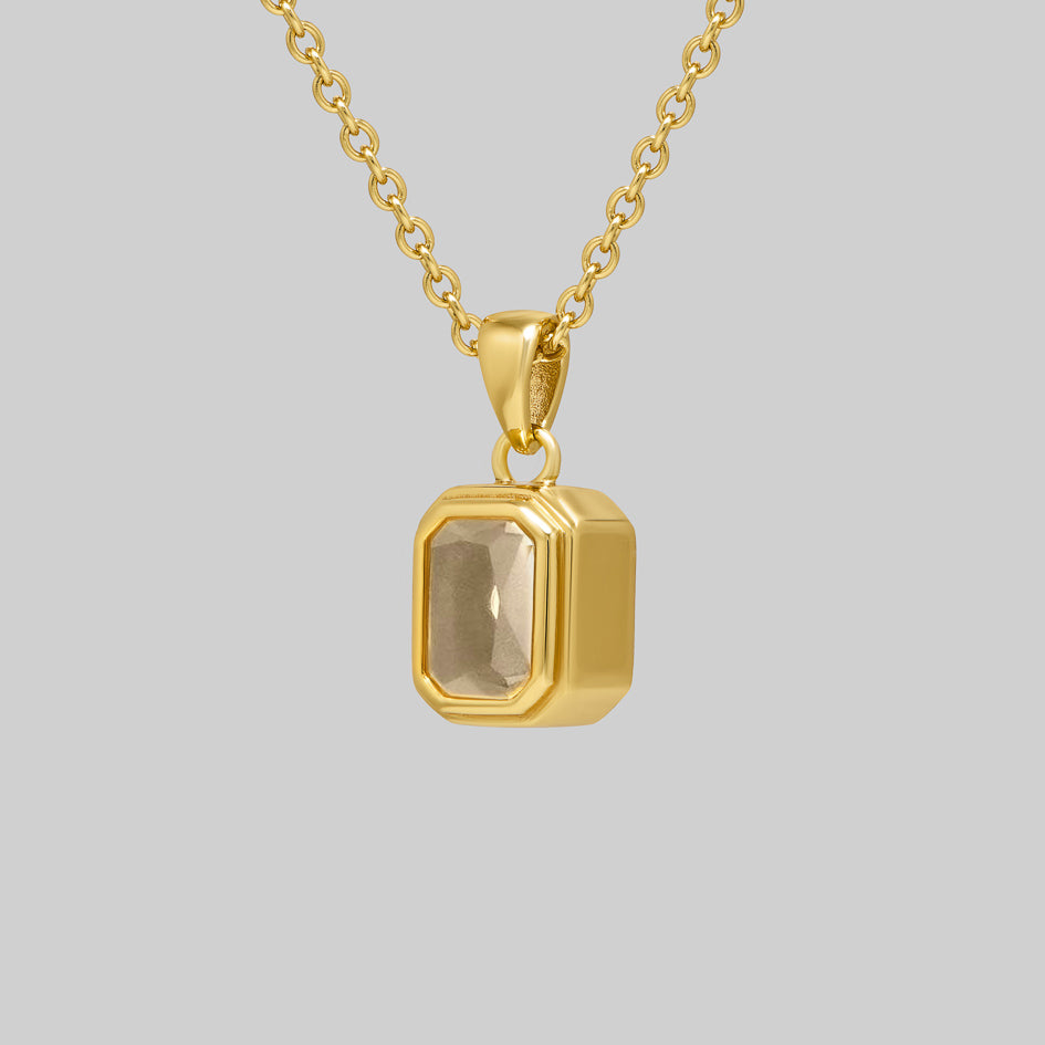 Side view of the gold Clear Quartz cremation pendant showing the bezel setting and pendant depth