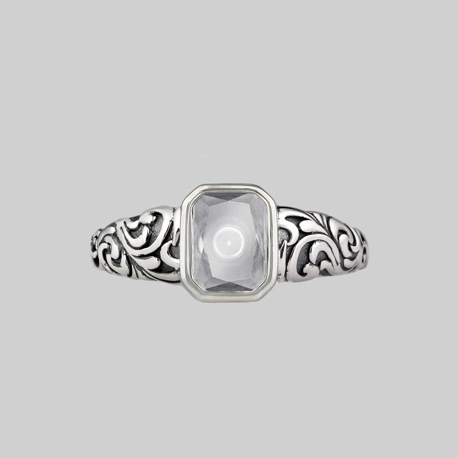 Sterling silver cremation ring with an emerald cut Clear Quartz window set between oxidised scroll engraved shoulders