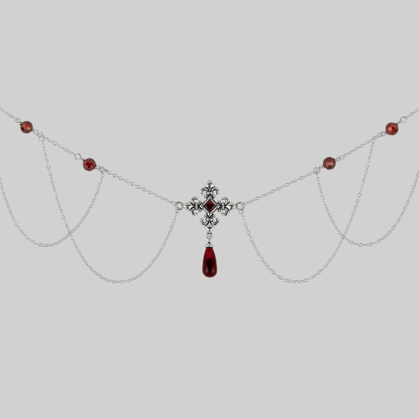 silver fleur-de-lis necklace with red gemstones