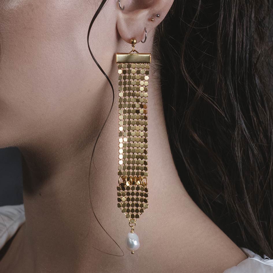 Model wearing Oda gold armoured pearl drop earrings