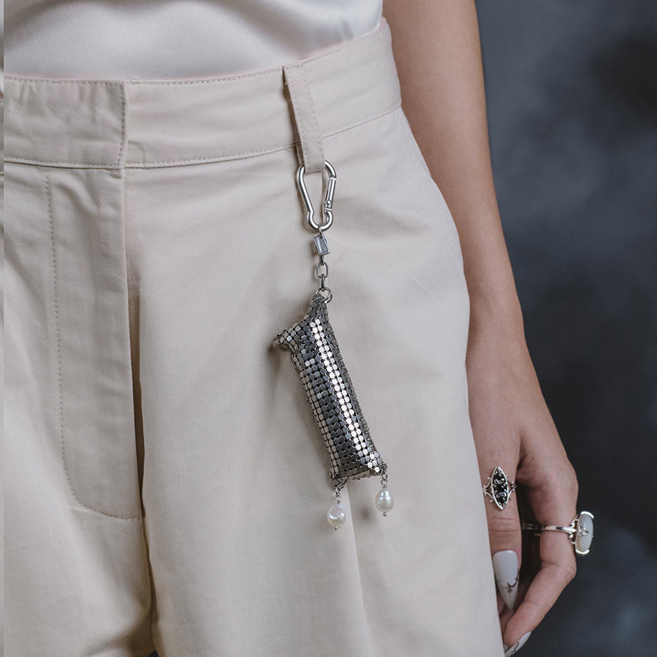 Model wearing Thea silver armoured pearl drop keyring pouch