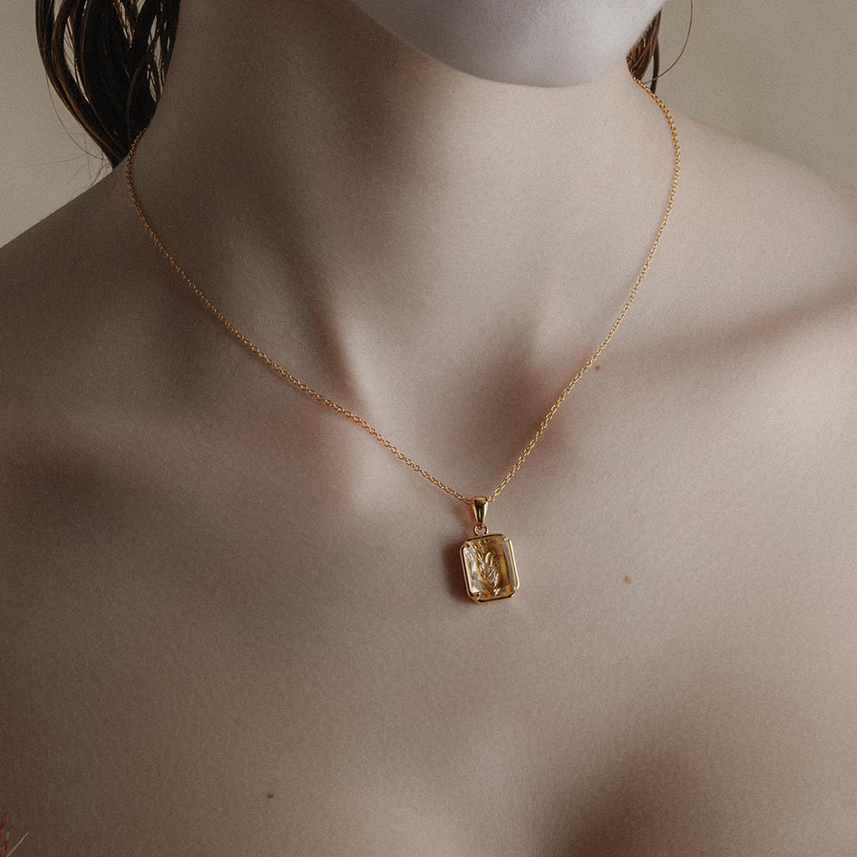 Gold plated 3D anatomical heart under glass necklace worn on a model