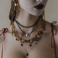 silver and gold layered gothic necklaces worn by model
