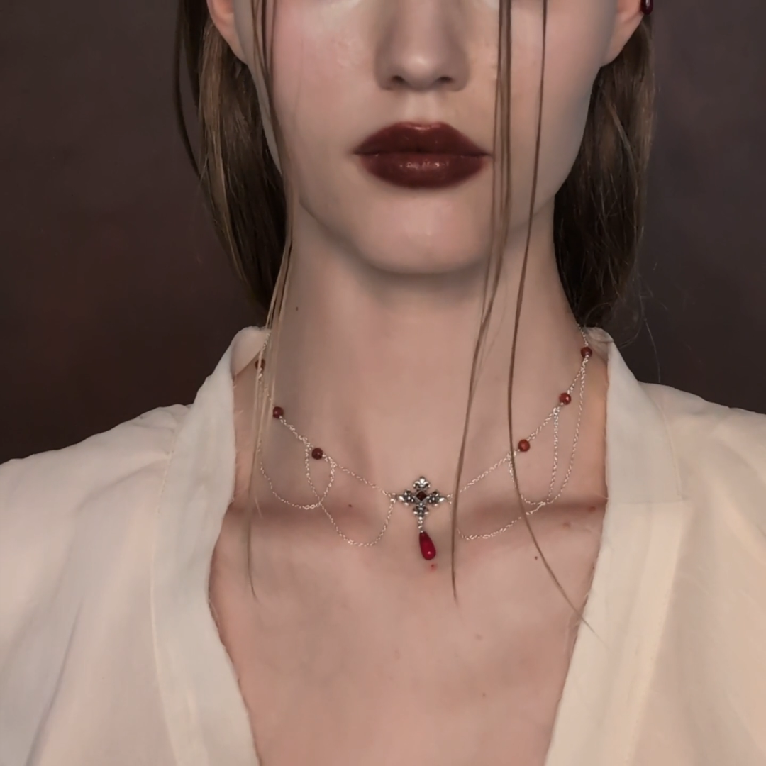 silver fleur-de-lis necklace with red gemstones