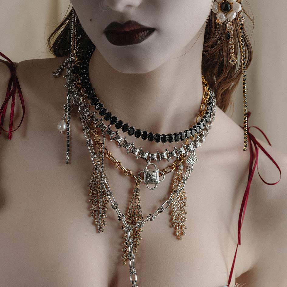 silver and gold layered gothic necklaces worn by model