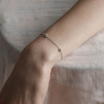 Silver dainty barbed wire bracelet worn on a models wrist
