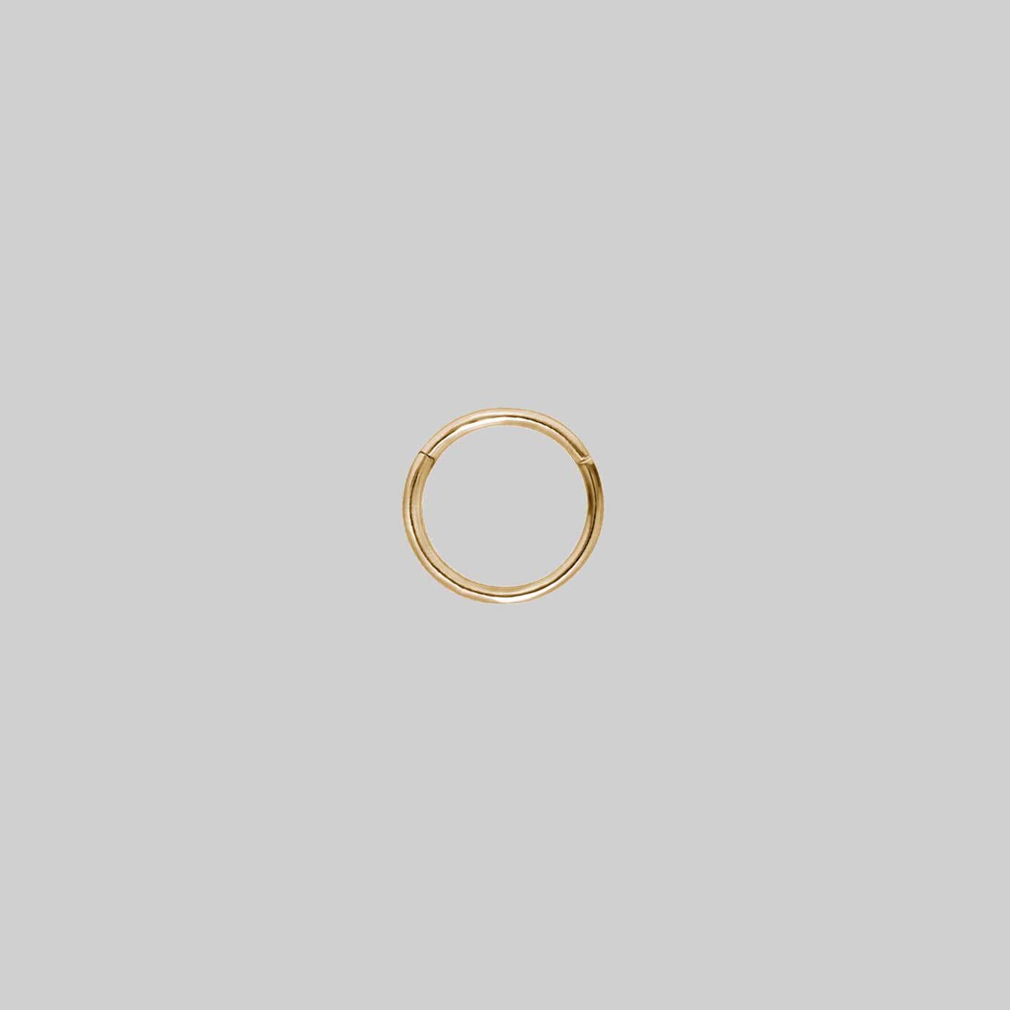 A small gold clicker ring with a simple design